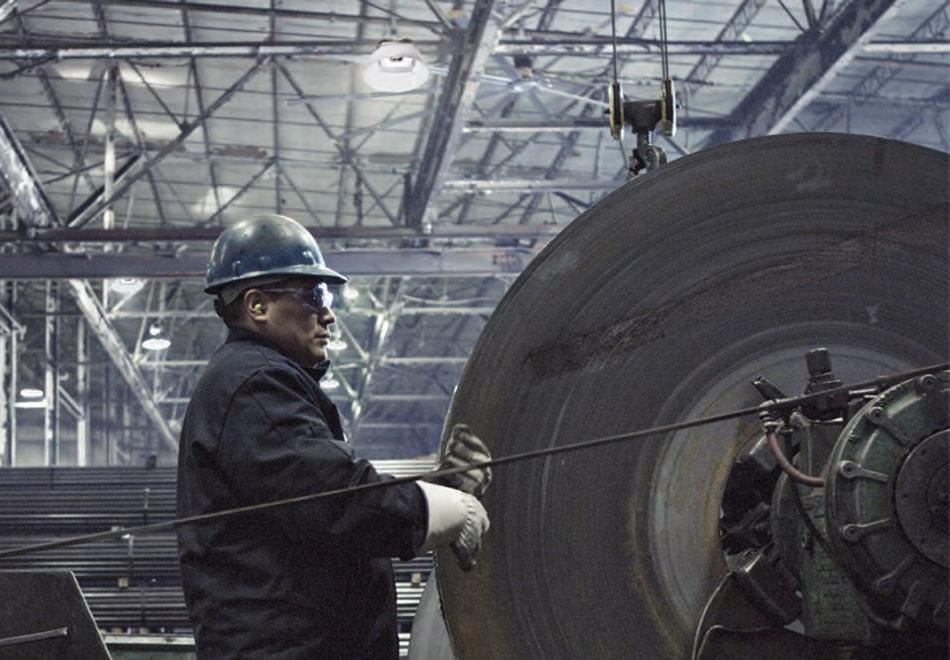 man working in a factory with high-bay lighting